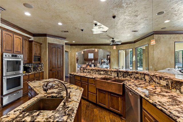 kitchen featuring sink, hanging light fixtures, ceiling fan, stainless steel appliances, and dark wood-type flooring