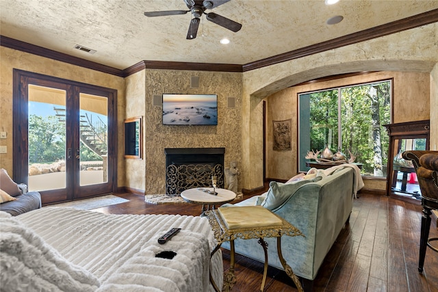 living room featuring a fireplace, dark hardwood / wood-style flooring, ceiling fan, crown molding, and french doors