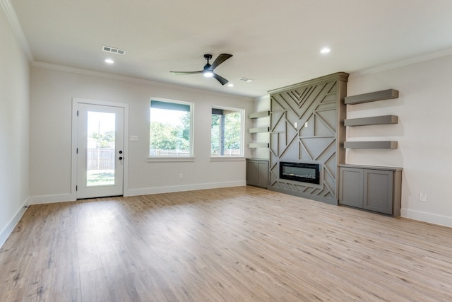 unfurnished living room featuring ceiling fan, light wood-type flooring, and ornamental molding