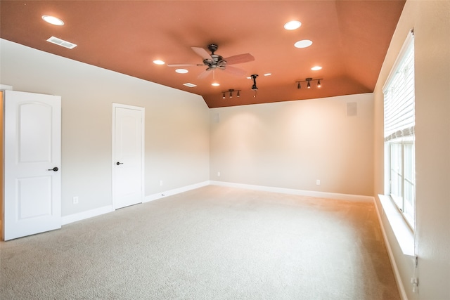 empty room featuring vaulted ceiling, ceiling fan, and light colored carpet