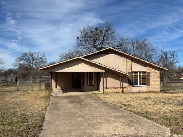 view of front of home featuring driveway, fence, and brick siding