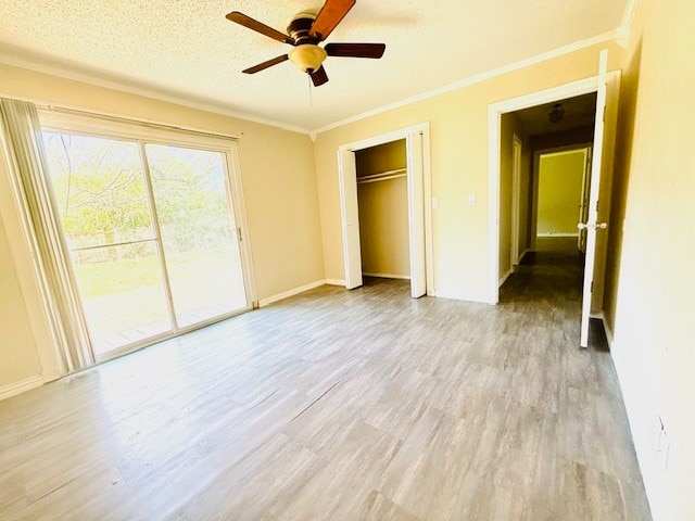 interior space featuring light hardwood / wood-style flooring, ceiling fan, crown molding, and a textured ceiling