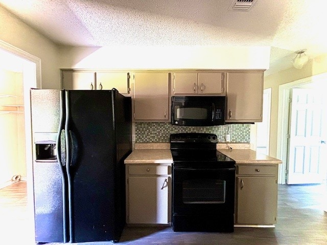 kitchen featuring a textured ceiling, backsplash, hardwood / wood-style floors, and black appliances