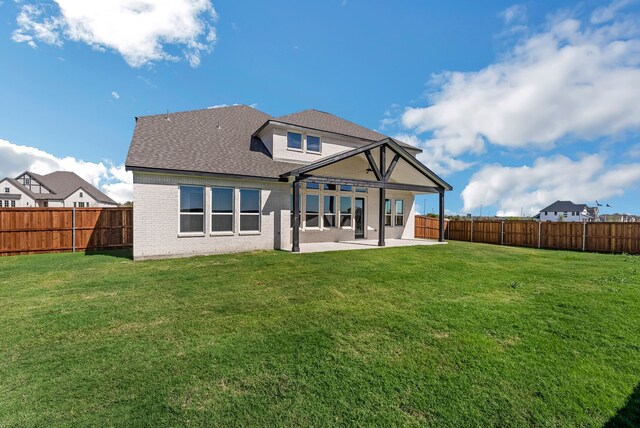 rear view of house with a patio area and a yard