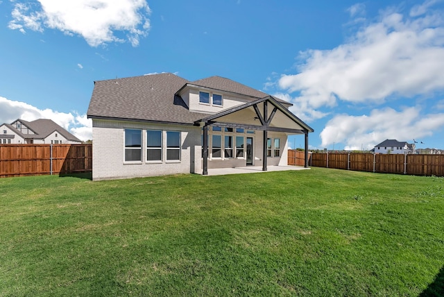 back of house featuring a lawn, a patio area, and a fenced backyard