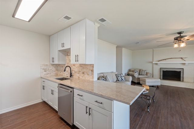 kitchen featuring sink, dishwasher, kitchen peninsula, and white cabinets