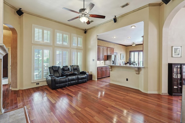 living room featuring crown molding, ceiling fan, and dark wood-type flooring