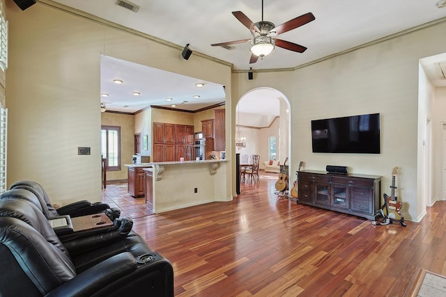 living room featuring ceiling fan, hardwood / wood-style floors, and crown molding