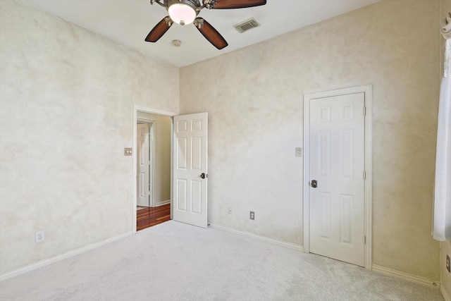 unfurnished bedroom with ceiling fan and light colored carpet