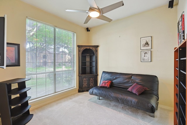 living area with ceiling fan and carpet flooring