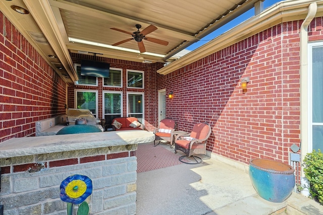 view of patio featuring ceiling fan, a grill, and an outdoor kitchen