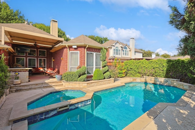 view of swimming pool featuring ceiling fan and an in ground hot tub