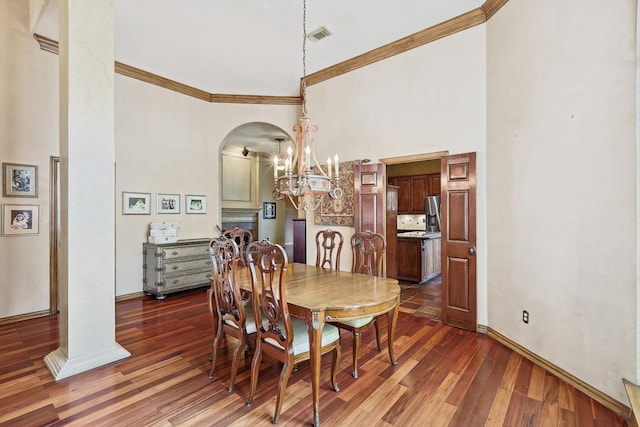 dining room featuring crown molding, dark hardwood / wood-style flooring, and a high ceiling