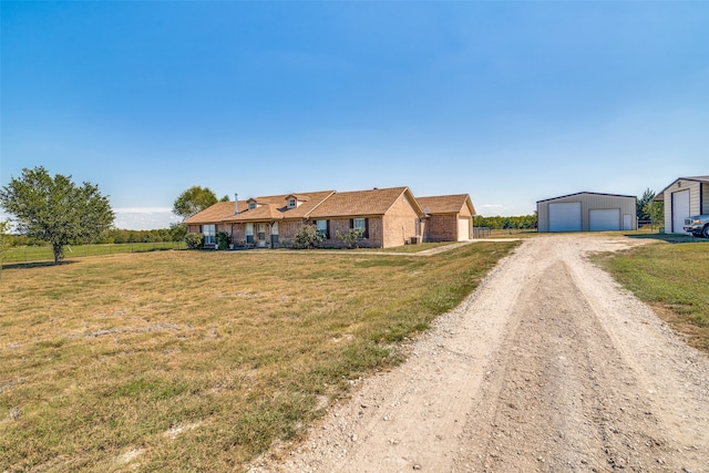 ranch-style house with a front yard, a garage, and an outdoor structure