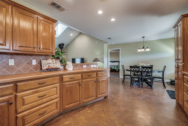 kitchen featuring decorative backsplash, a notable chandelier, tile countertops, and hanging light fixtures