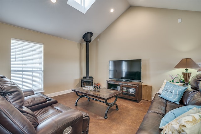 living room featuring light carpet, a skylight, a wood stove, and high vaulted ceiling