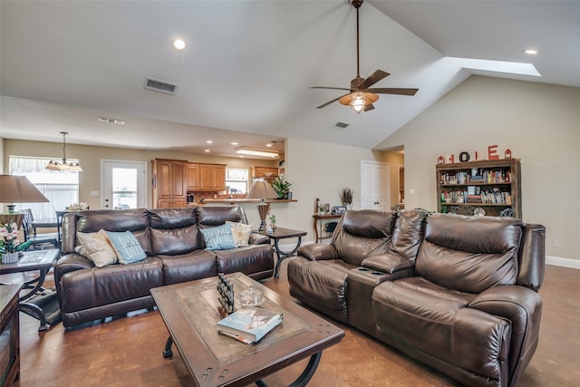 living room with vaulted ceiling with skylight and ceiling fan