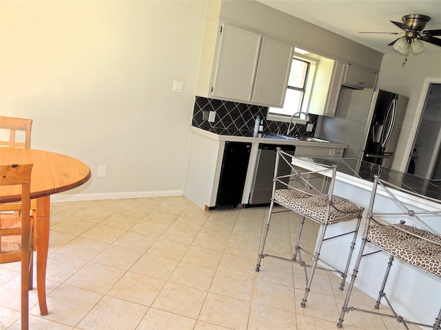 kitchen featuring stainless steel fridge with ice dispenser, sink, white cabinetry, decorative backsplash, and ceiling fan