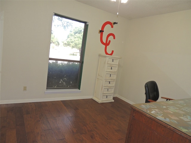 unfurnished office with a textured ceiling and dark hardwood / wood-style floors