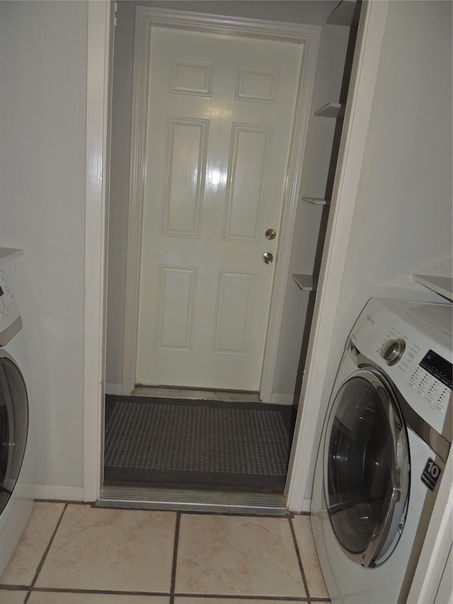 laundry area with washer / clothes dryer and light tile patterned floors