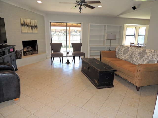 tiled living room featuring a healthy amount of sunlight, a fireplace, ornamental molding, and ceiling fan