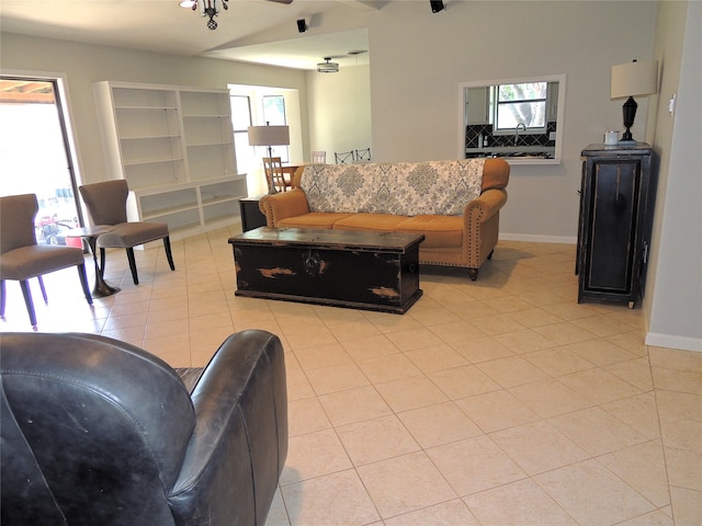 living room featuring ceiling fan, light tile patterned flooring, and built in features