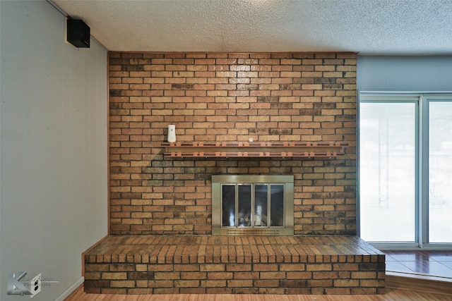 details featuring wood-type flooring, a textured ceiling, and a fireplace