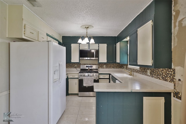 kitchen featuring a textured ceiling, sink, hanging light fixtures, an inviting chandelier, and stainless steel appliances