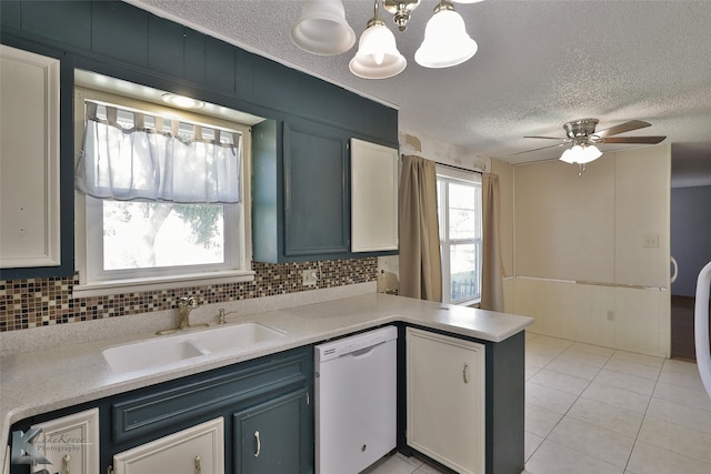 kitchen featuring decorative backsplash, ceiling fan with notable chandelier, white dishwasher, decorative light fixtures, and sink