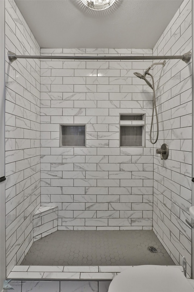 bathroom with tiled shower and toilet