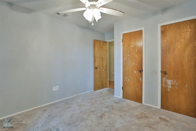 unfurnished bedroom with light carpet, a textured ceiling, and ceiling fan