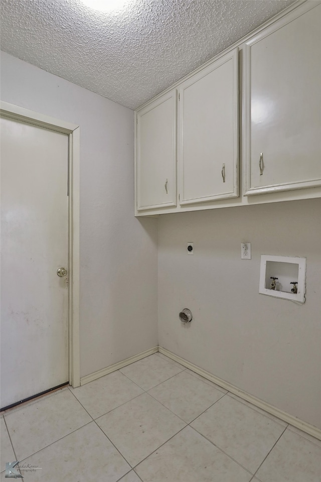 laundry area with light tile patterned floors, hookup for an electric dryer, a textured ceiling, cabinets, and hookup for a washing machine