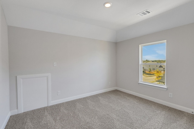 spare room featuring vaulted ceiling and carpet