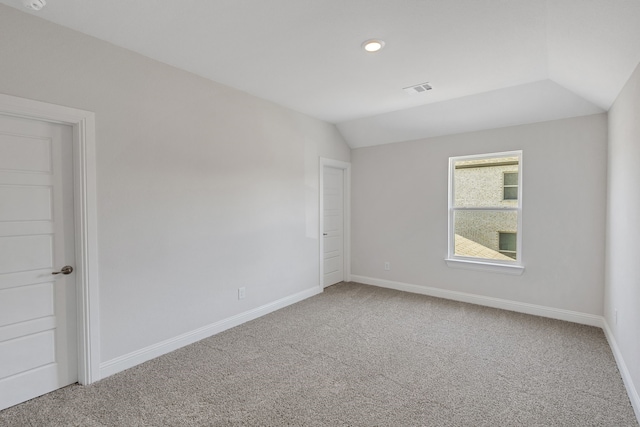 unfurnished room featuring lofted ceiling and carpet floors