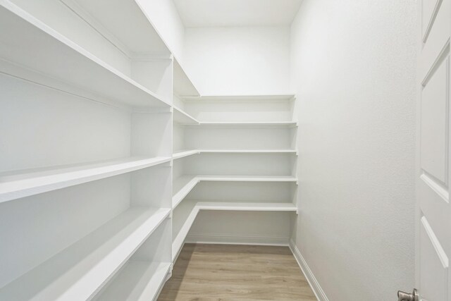 room details with white cabinets, wall chimney exhaust hood, and backsplash