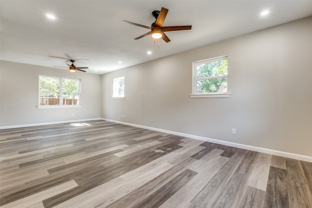 spare room with light hardwood / wood-style flooring, ceiling fan, and plenty of natural light