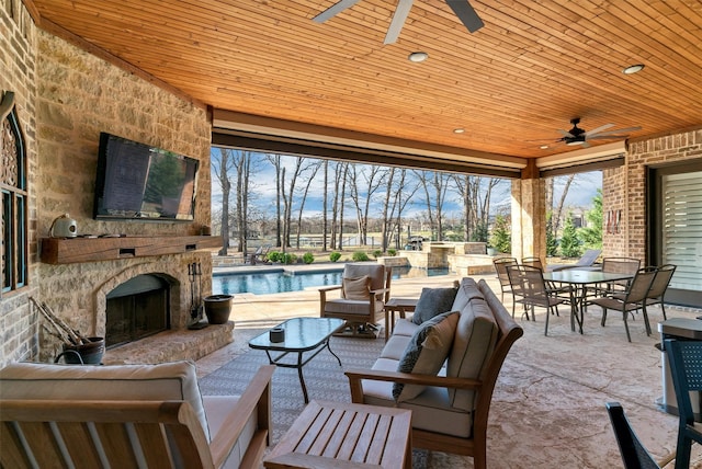 view of patio featuring ceiling fan and an outdoor living space with a fireplace