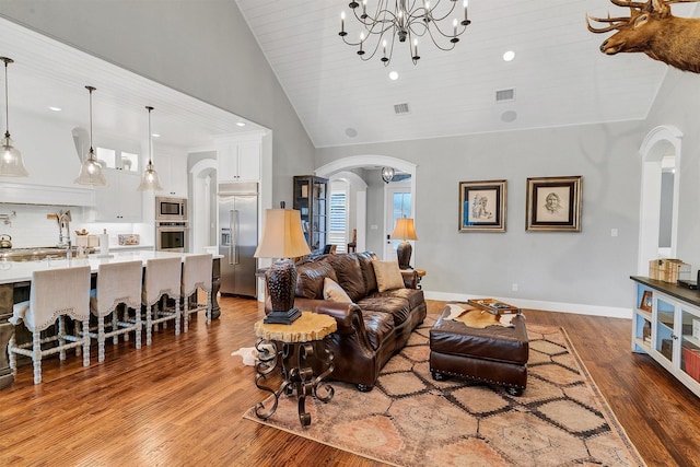 living room featuring wooden ceiling, wood-type flooring, lofted ceiling, and a chandelier