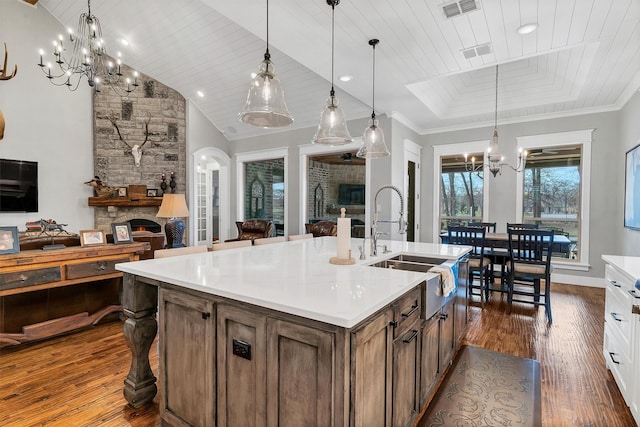 kitchen featuring wooden ceiling, a fireplace, an inviting chandelier, pendant lighting, and dark hardwood / wood-style flooring