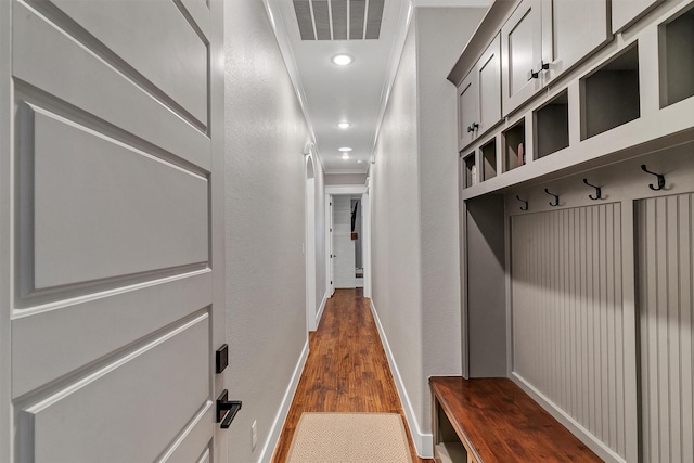 mudroom with crown molding and dark wood-type flooring