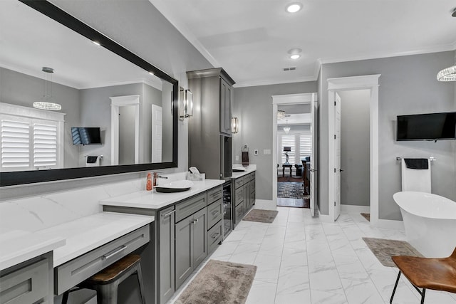 bathroom with a washtub, vanity, and ornamental molding