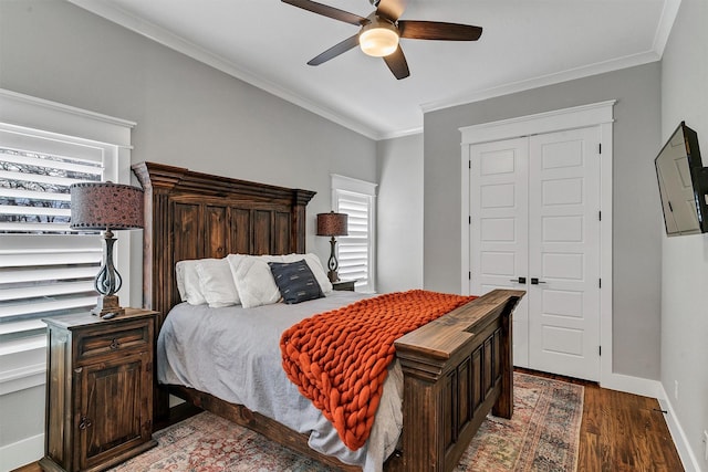 bedroom with crown molding, multiple windows, dark hardwood / wood-style floors, and ceiling fan