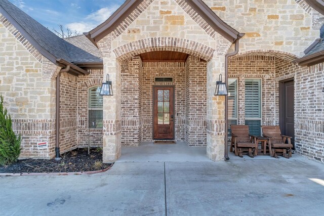1552 Laguna Bay N, Pelican Bay, TX 76020 - view of exterior entry featuring brick siding, a shingled roof, and stone siding