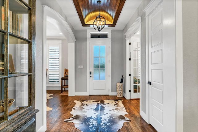 entryway featuring a notable chandelier, dark hardwood / wood-style floors, and a tray ceiling