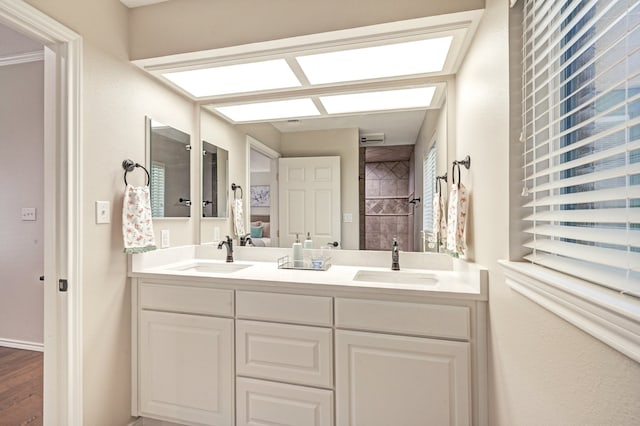 bathroom with a shower, hardwood / wood-style floors, and vanity