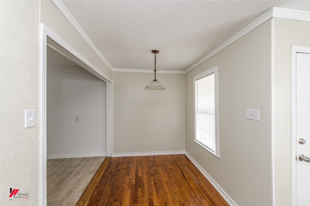 unfurnished dining area with wood-type flooring, a textured ceiling, and ornamental molding