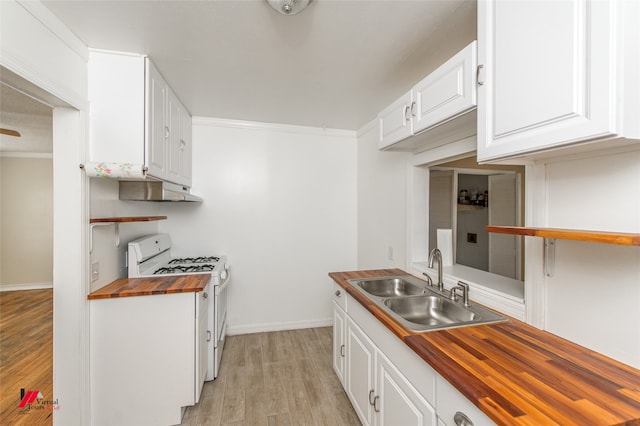 kitchen featuring white cabinets, gas range gas stove, butcher block counters, light hardwood / wood-style flooring, and sink