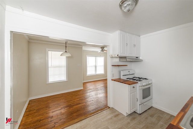 kitchen with hanging light fixtures, white cabinetry, light hardwood / wood-style floors, white range with gas cooktop, and butcher block counters