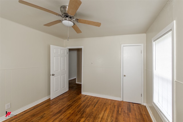 unfurnished bedroom with ceiling fan, crown molding, and dark hardwood / wood-style flooring