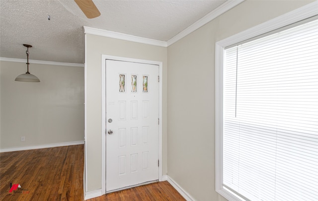 foyer entrance with a textured ceiling, dark hardwood / wood-style floors, and ornamental molding